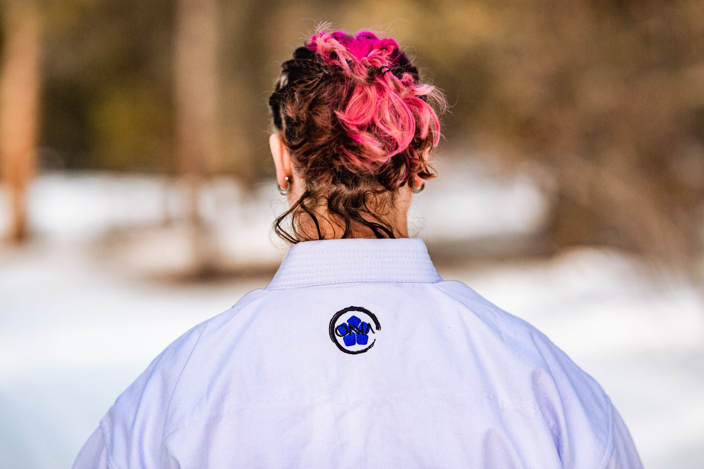 Onna Kimono embroidered logo at back neck of karate uniform. 