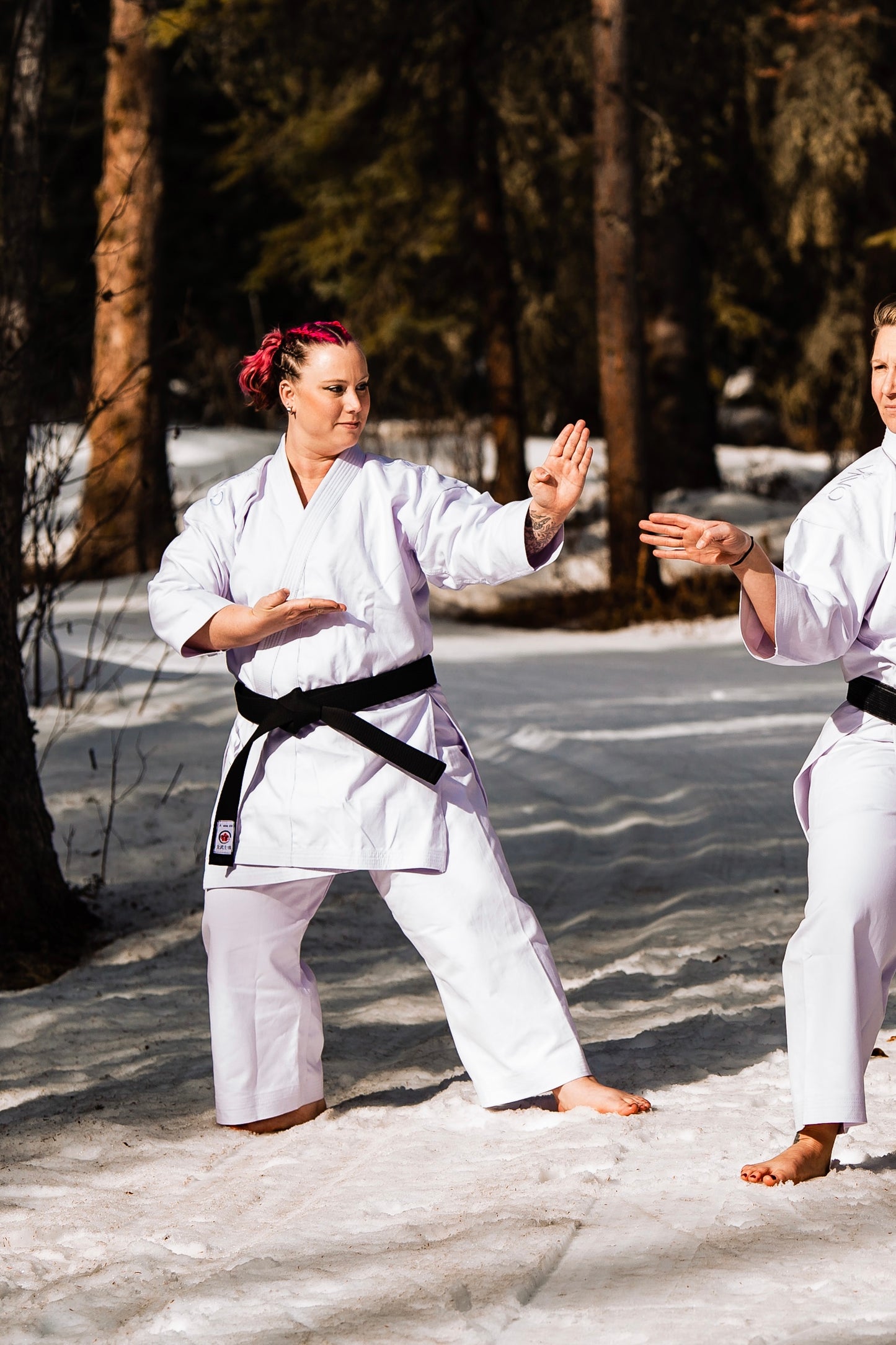 plus sized woman in karate uniform with black belt in the snow.