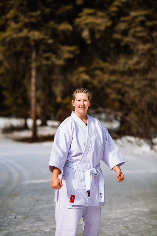 Woman wearing karate gi with white belt in the snow